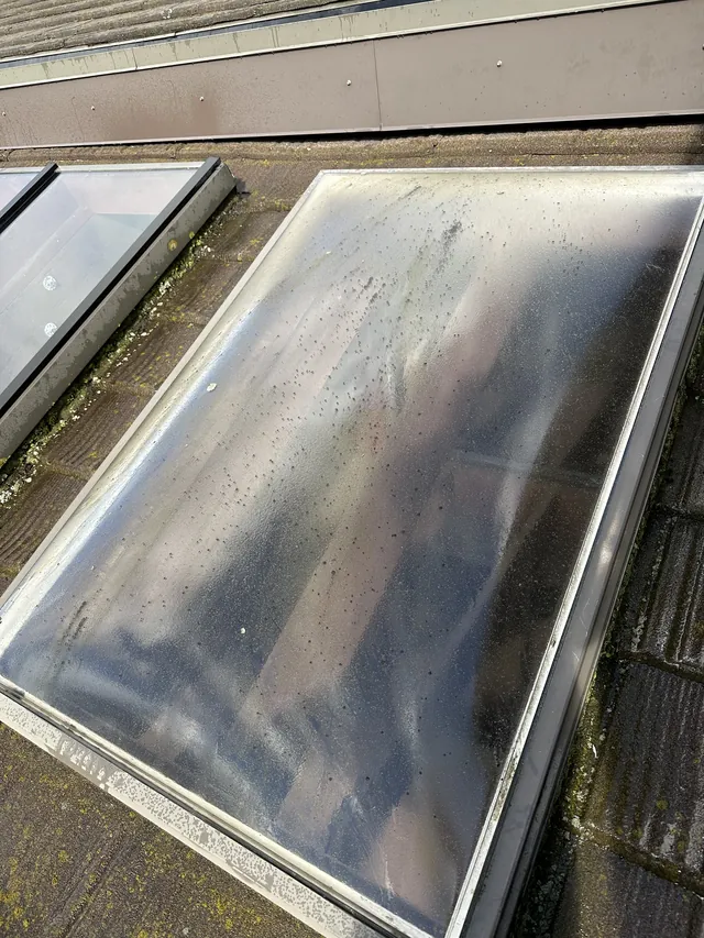Surface buildup on skylight glass before cleaning.