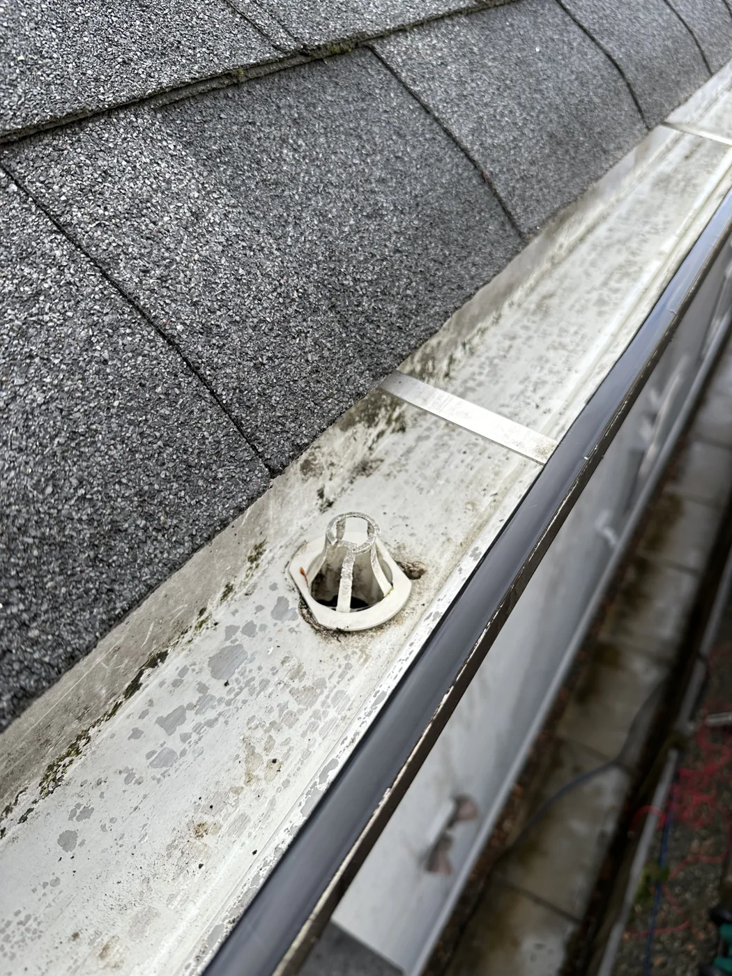 Gutter outlet and channel exposed after debris removal