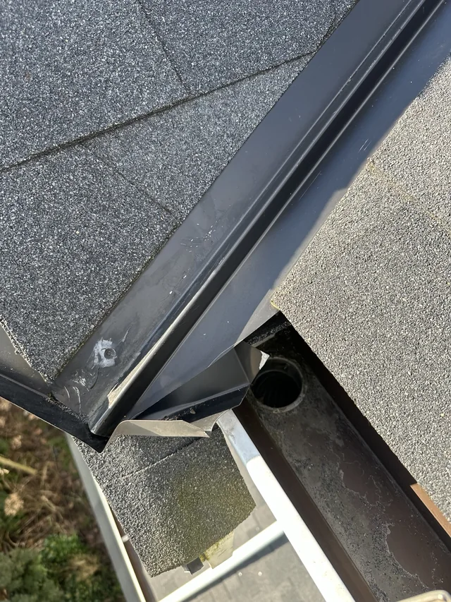 Gutter outlet below the roof valley before sealant application.