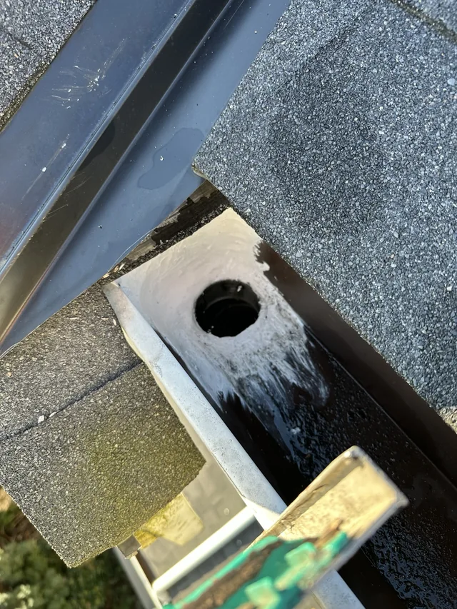 Sealant being applied around the same gutter outlet, with a brush visible.