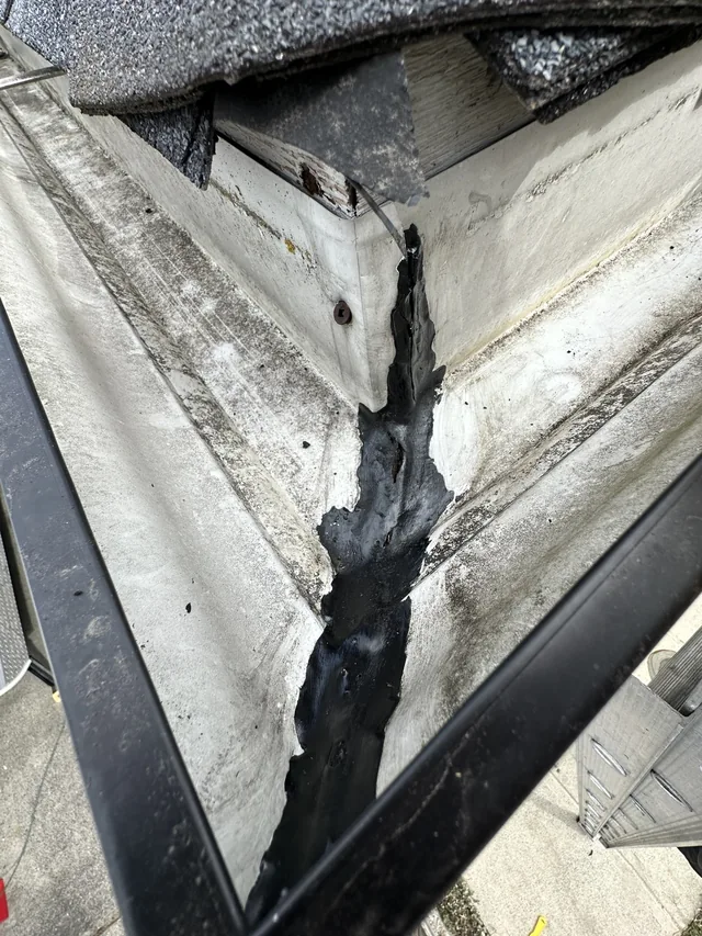 Second gutter corner seam with old dark sealant beneath the roof edge.